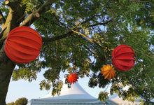 Lade das Bild in den Galerie-Viewer, Barloon Alrabi Metall & Design Lampions in rot und gelb und orange im Baum hängend